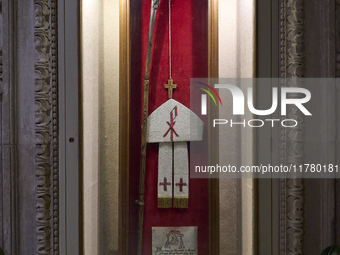 This image shows the wooden pastoral symbols of Italian Bishop Tonino Bello, including his mitre, pastoral staff, wooden cross, and ring. Bi...