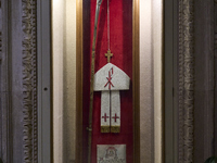 This image shows the wooden pastoral symbols of Italian Bishop Tonino Bello, including his mitre, pastoral staff, wooden cross, and ring. Bi...