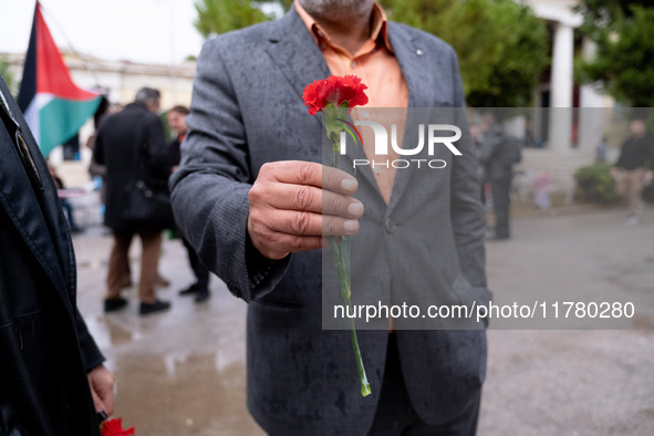 A man holds a carnation near a monument inside the Athens Polytechnic during the celebration of the 51st anniversary of the Polytechnic upri...