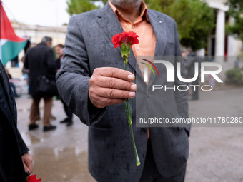 A man holds a carnation near a monument inside the Athens Polytechnic during the celebration of the 51st anniversary of the Polytechnic upri...