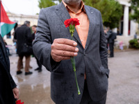 A man holds a carnation near a monument inside the Athens Polytechnic during the celebration of the 51st anniversary of the Polytechnic upri...