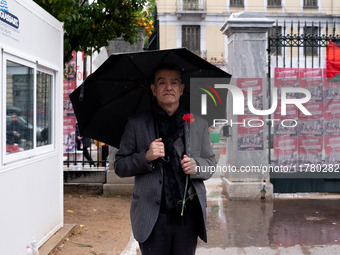 A man holds a carnation near a monument inside the Athens Polytechnic during the celebration of the 51st anniversary of the Polytechnic upri...