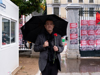 A man holds a carnation near a monument inside the Athens Polytechnic during the celebration of the 51st anniversary of the Polytechnic upri...