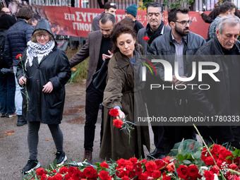 A woman lays a carnation on a monument inside the Athens Polytechnic during the celebration of the 51st anniversary of the Polytechnic upris...