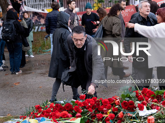 A man lays a carnation on a monument inside the Athens Polytechnic during the celebration of the 51st anniversary of the Polytechnic uprisin...