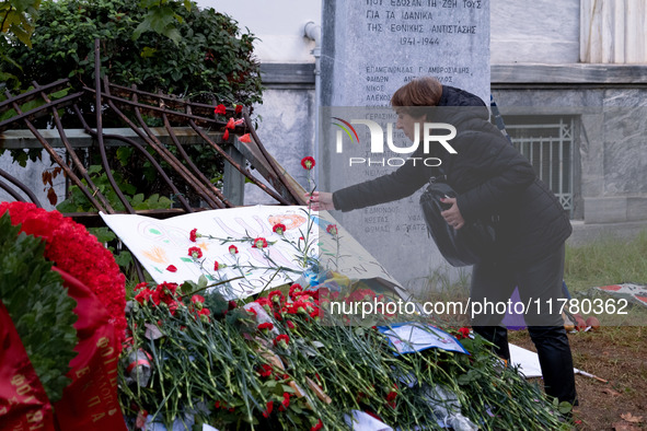 A woman lays a carnation on a monument inside the Athens Polytechnic during the celebration of the 51st anniversary of the Polytechnic upris...