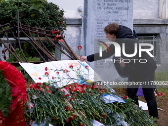 A woman lays a carnation on a monument inside the Athens Polytechnic during the celebration of the 51st anniversary of the Polytechnic upris...