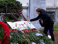 A woman lays a carnation on a monument inside the Athens Polytechnic during the celebration of the 51st anniversary of the Polytechnic upris...