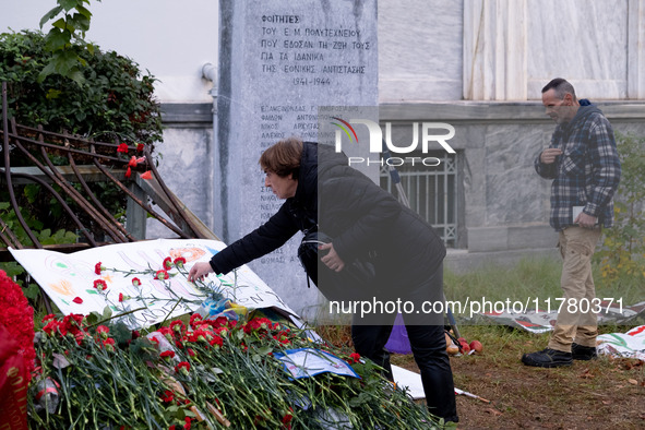 A woman lays a carnation on a monument inside the Athens Polytechnic during the celebration of the 51st anniversary of the Polytechnic upris...