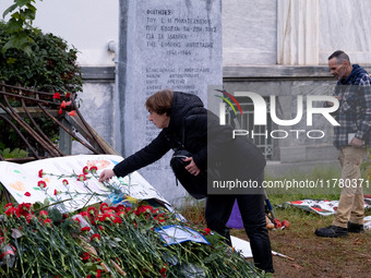 A woman lays a carnation on a monument inside the Athens Polytechnic during the celebration of the 51st anniversary of the Polytechnic upris...