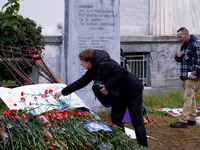 A woman lays a carnation on a monument inside the Athens Polytechnic during the celebration of the 51st anniversary of the Polytechnic upris...