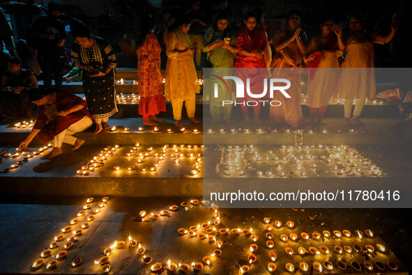 Devotees light oil lamps and chant prayers at a riverside of the Ganges in Kolkata, India, on November 15, 2024, during the Dev Deepavali ce...