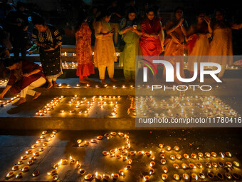 Devotees light oil lamps and chant prayers at a riverside of the Ganges in Kolkata, India, on November 15, 2024, during the Dev Deepavali ce...