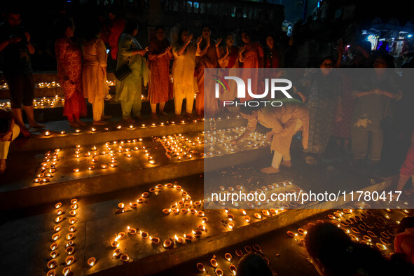 Devotees light oil lamps and chant prayers at a riverside of the Ganges in Kolkata, India, on November 15, 2024, during the Dev Deepavali ce...