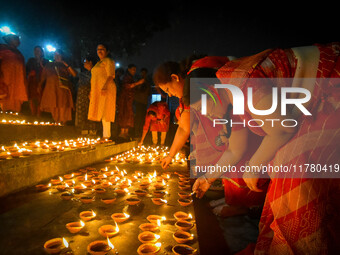 A lady lights oil lamps at the riverside of the Ganges in Kolkata, India, on November 15, 2024, during the Dev Deepavali celebration in the...