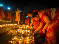 A lady lights oil lamps at the riverside of the Ganges in Kolkata, India, on November 15, 2024, during the Dev Deepavali celebration in the...