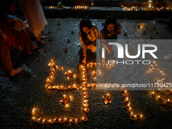 Devotees light oil lamps at the riverside of the Ganges in Kolkata, India, on November 15, 2024, during the Dev Deepavali celebration in the...