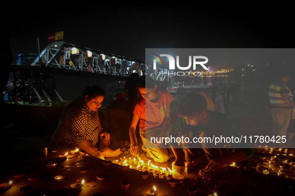 Devotees light oil lamps at the riverside of the Ganges in Kolkata, India, on November 15, 2024, during the Dev Deepavali celebration in the...