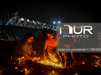 Devotees light oil lamps at the riverside of the Ganges in Kolkata, India, on November 15, 2024, during the Dev Deepavali celebration in the...