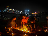 Devotees light oil lamps at the riverside of the Ganges in Kolkata, India, on November 15, 2024, during the Dev Deepavali celebration in the...