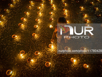 A child lights oil lamps at the riverside of the Ganges in Kolkata, India, on November 15, 2024, during the Dev Deepavali celebration in the...