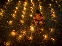 A child lights oil lamps at the riverside of the Ganges in Kolkata, India, on November 15, 2024, during the Dev Deepavali celebration in the...