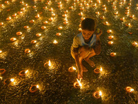 A child lights oil lamps at the riverside of the Ganges in Kolkata, India, on November 15, 2024, during the Dev Deepavali celebration in the...