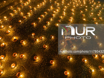 A child lights oil lamps at the riverside of the Ganges in Kolkata, India, on November 15, 2024, during the Dev Deepavali celebration in the...