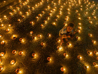 A child lights oil lamps at the riverside of the Ganges in Kolkata, India, on November 15, 2024, during the Dev Deepavali celebration in the...