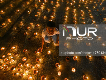 A child lights oil lamps at the riverside of the Ganges in Kolkata, India, on November 15, 2024, during the Dev Deepavali celebration in the...