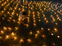 A child lights oil lamps at the riverside of the Ganges in Kolkata, India, on November 15, 2024, during the Dev Deepavali celebration in the...