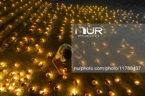 A child lights oil lamps at the riverside of the Ganges in Kolkata, India, on November 15, 2024, during the Dev Deepavali celebration in the...