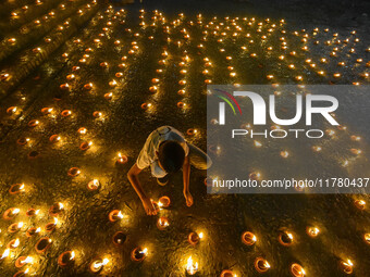 A child lights oil lamps at the riverside of the Ganges in Kolkata, India, on November 15, 2024, during the Dev Deepavali celebration in the...