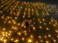 A child lights oil lamps at the riverside of the Ganges in Kolkata, India, on November 15, 2024, during the Dev Deepavali celebration in the...