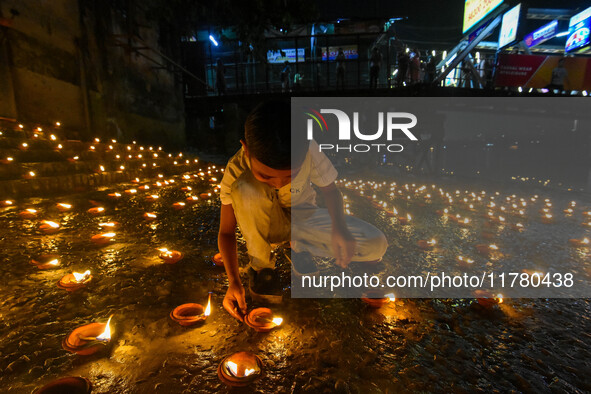 A child lights oil lamps at the riverside of the Ganges in Kolkata, India, on November 15, 2024, during the Dev Deepavali celebration in the...