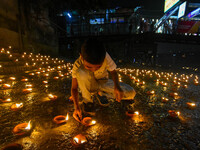 A child lights oil lamps at the riverside of the Ganges in Kolkata, India, on November 15, 2024, during the Dev Deepavali celebration in the...