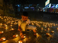 A child lights oil lamps at the riverside of the Ganges in Kolkata, India, on November 15, 2024, during the Dev Deepavali celebration in the...