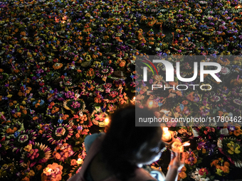 People float Krathong offerings at a park lake during the Thai annual Loy Krathong festival in Bangkok, Thailand, on November 15, 2024. The...