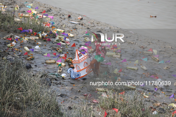 A girl collects items thrown by devotees as religious offerings after the celebrations of the 'Boita Bandana,' also known as 'Danga Bhasa,'...