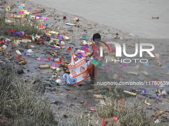 A girl collects items thrown by devotees as religious offerings after the celebrations of the 'Boita Bandana,' also known as 'Danga Bhasa,'...