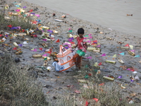 A girl collects items thrown by devotees as religious offerings after the celebrations of the 'Boita Bandana,' also known as 'Danga Bhasa,'...