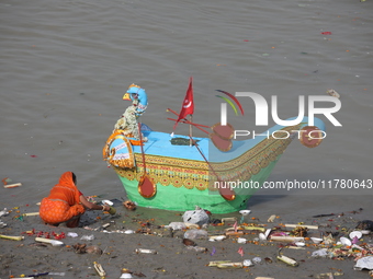 A woman collects items thrown by devotees as religious offerings after the celebrations of the 'Boita Bandana,' also known as 'Danga Bhasa,'...