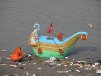 A woman collects items thrown by devotees as religious offerings after the celebrations of the 'Boita Bandana,' also known as 'Danga Bhasa,'...