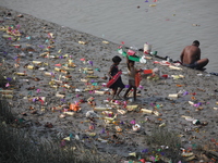 Girls collect items thrown by devotees as religious offerings after the celebrations of the 'Boita Bandana,' also known as ''Danga Bhasa,''...