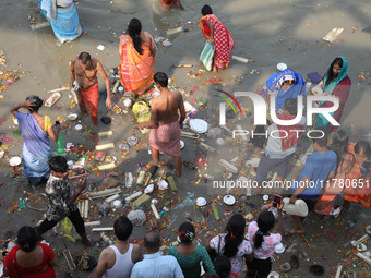 People collect items thrown by devotees as religious offerings after the celebrations of the 'Boita Bandana,' also known as 'Danga Bhasa,' o...