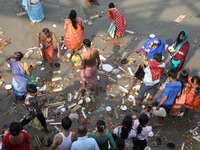 People collect items thrown by devotees as religious offerings after the celebrations of the 'Boita Bandana,' also known as 'Danga Bhasa,' o...