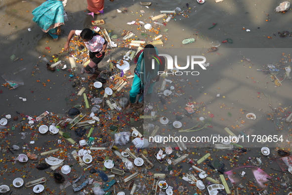 A woman collects items thrown by devotees as religious offerings after the celebrations of the 'Boita Bandana,' also known as 'Danga Bhasa,'...