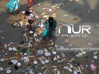 A woman collects items thrown by devotees as religious offerings after the celebrations of the 'Boita Bandana,' also known as 'Danga Bhasa,'...