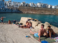 Swimmers relax in the warm Mediterranean waters on a sunny Sunday afternoon in Monopoli, Italy, on October 27, 2024. This image shows the co...