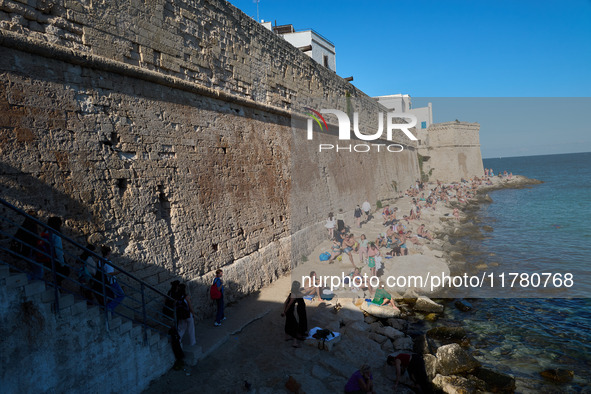 Swimmers relax in the warm Mediterranean waters on a sunny Sunday afternoon in Monopoli, Italy, on October 27, 2024. This image shows the co...